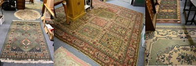 Lot 1227 - A Middle Eastern carpet decorated with sixteen panels of flowers within conforming borders,...