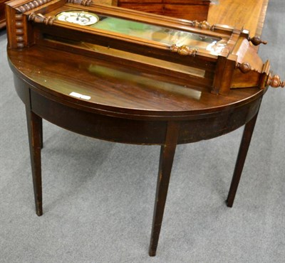 Lot 1367 - A 19th century mahogany demi lune fold over tea table