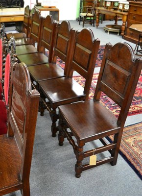 Lot 1405 - A set of eight provincial oak panel back and plank seated dining chairs