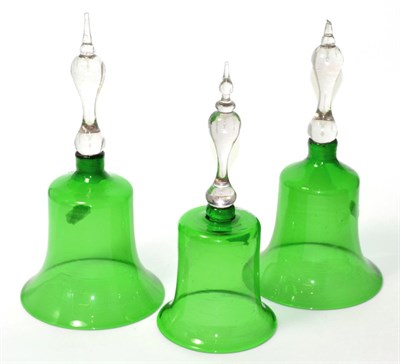 Lot 16 - Three green glass table bells with clear glass handles, tallest 23cm high