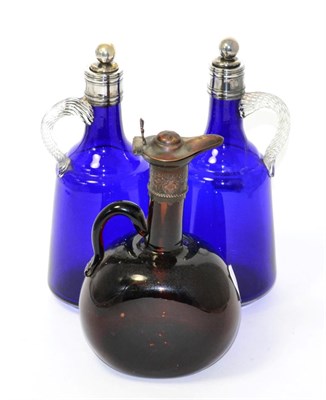 Lot 39 - A pair of plate mounted blue glass bottles together with a brown glass example