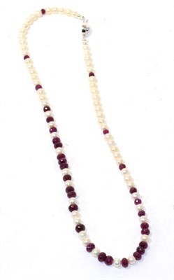 Lot 126 - A cultured pearl and faceted ruby bead necklace with ruby set clasp, 54cm long