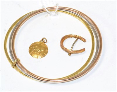 Lot 286 - A three colour bangle stamped '375', a horseshoe brooch and a charm (3)