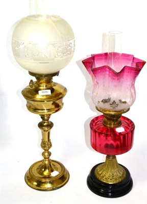 Lot 406 - Two oil lamps with glass shades, one being a cranberry glass oil lamp