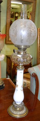 Lot 446 - A Victorian oil lamp with floral painted glass upright and a clear glass reservoir, with etched...