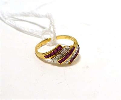 Lot 478 - A ruby and diamond ring, three diagonal bands of step cut rubies in yellow channel settings, spaced