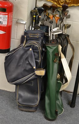 Lot 1169 - A quantity of golf clubs in four golfing bags and a snooker cue