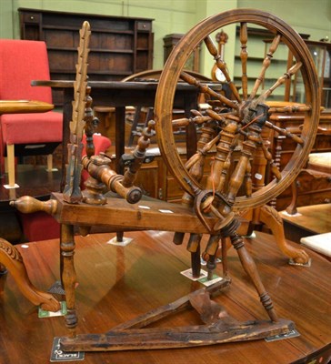 Lot 1309 - A 19th century pine and fruitwood spinning wheel, the bobbin turned wheel raised on four turned...