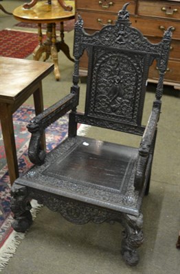 Lot 1318 - An Anglo-Burmese hardwood open armchair, allover blind carved with deities, floral and foliate...