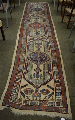 Lot 1342 - Sarab runner, Iranian Azerbaijan, the pale camel field with a column of stepped lozenge...