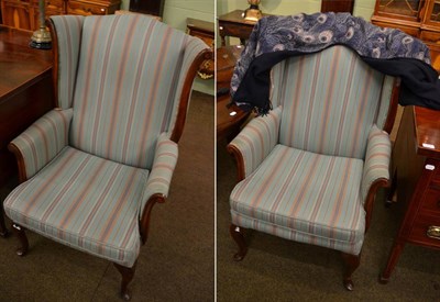 Lot 1396 - A pair of early 20th century mahogany framed wing-back armchairs, recovered in green and pink...