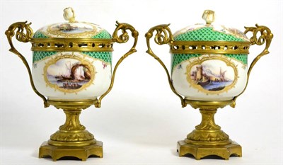 Lot 189 - A pair of gilt metal mounted painted porcelain urns and covers decorated with vignettes of...