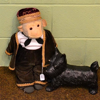 Lot 298 - A 1920's straw filled monkey with felt ears and a pottery black scottie dog (2)