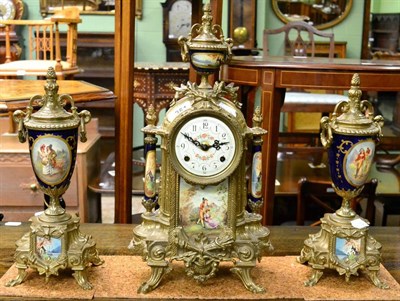 Lot 351 - A reproduction gilt metal, porcelain mounted, striking mantel clock with urn shaped garniture