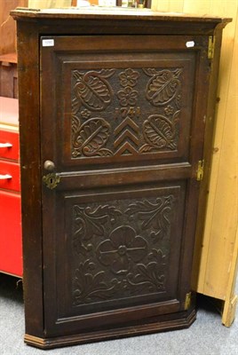 Lot 1090 - A carved oak corner cupboard, dated 1741