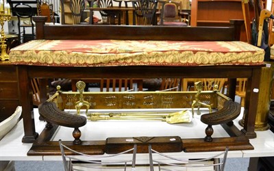 Lot 1113 - An early 20th century mahogany window seat, a carved oak club fender, a brass fender, andirons...