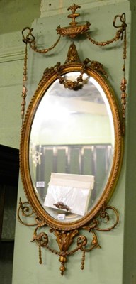 Lot 1200 - A mid 19th century gesso wall mirror with urn and ribbon tied swag pediment