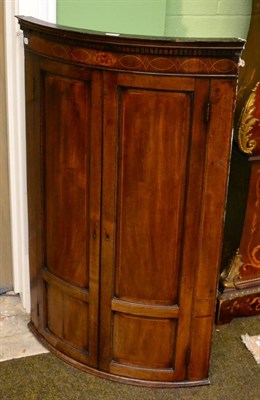 Lot 1231 - A George III bow-fronted hanging corner cupboard