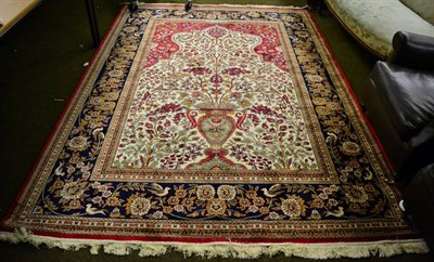 Lot 1274 - A machine made artificial silk prayer rug of Isfahan design the ivory field with an urn issuing...