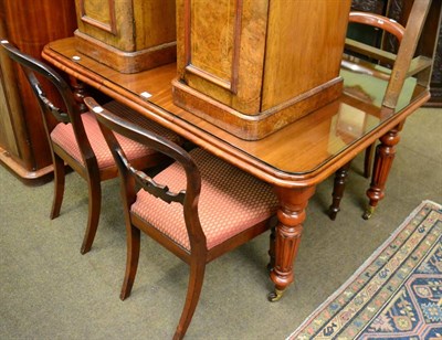 Lot 1328 - A mahogany table with one leaf, winder and glass top and a set of four mahogany balloon back chairs