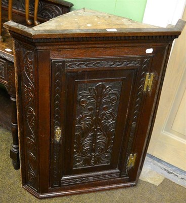 Lot 1343 - A carved oak corner cabinet