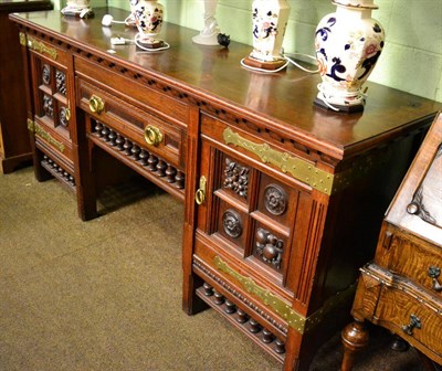 Lot 1357 - An Arts & Crafts oak sideboard, stamped 'Thos. Turner Manchester', heavily carved detail, brass...