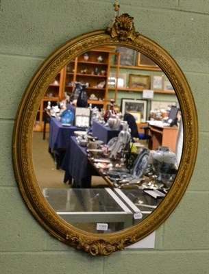 Lot 1385 - An oval gilt gesso wall mirror, with foliate border