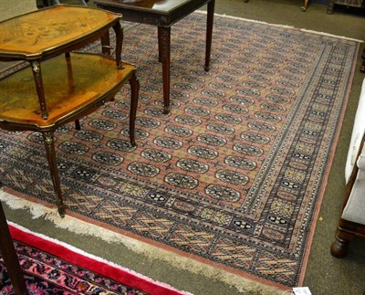 Lot 1389 - A machine made carpet, of Tekke design, the field with columns of quartered guls enclosed by...