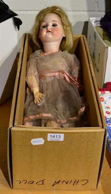 Lot 1413 - A German bisque socket head doll with wood and composition ball jointed body, wearing a cream...