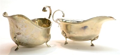 Lot 274 - A George VI silver sauceboat, ES Barnsley, Birmingham 1938, with flying scroll handle and three...