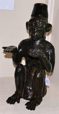 Lot 303 - A bronze figure of a seated monkey in a fez, 20th Century, modelled seated with arms...