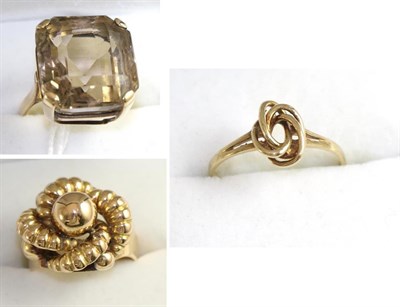 Lot 327 - A smokey quartz ring, stamped '9CT', finger size M, a large knot ring, stamped '18CT', finger...