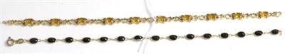 Lot 333 - A 9ct gold citrine and green stone bracelet and a sapphire line bracelet stamped '14k' (2)