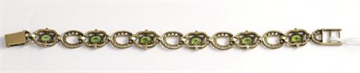 Lot 349 - A 9ct gold peridot horseshoe link bracelet