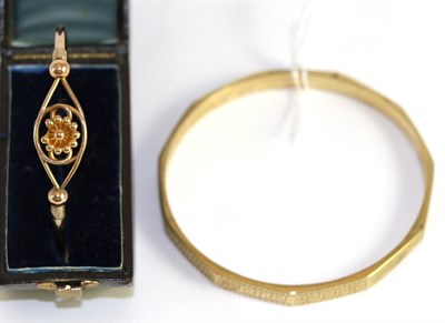 Lot 370 - A 9ct gold bangle, and another bangle with floral motif (2)