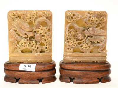 Lot 434 - A pair of early 20th century Chinese alabaster bookends, on hardwood bases, carved with dragons...