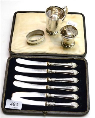 Lot 494 - A cased set of six silver handled tea knives, silver christening mug, silver egg cup and '830'...