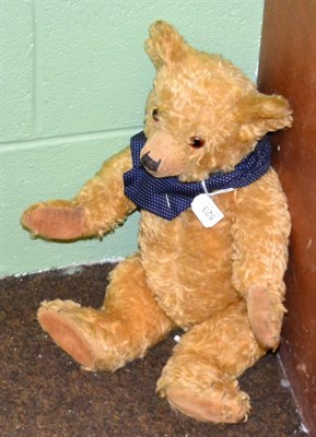 Lot 523 - A yellow plush jointed teddy bear with a 9ct gold, turquoise set wishbone stick pin