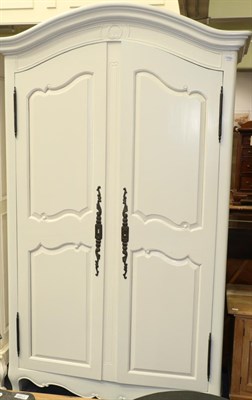 Lot 1169 - A cream painted armoire of recent date with moulded canopy top above panel doors enclosing...