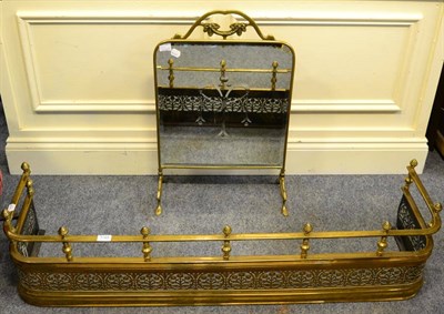 Lot 1185 - A late 19th century brass fender with pierced flowerhead decoration and a brass framed mirrored...