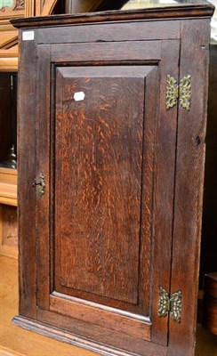 Lot 1225 - A Georgian oak hanging corner cupboard