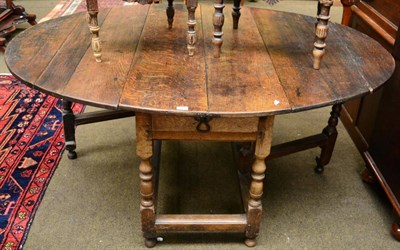 Lot 1252 - An early 18th century joined oak six-seater gateleg table, raised on spindle turned legs joined...