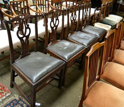 Lot 1269 - A set of four George III carved mahogany dining chairs with yoke crest rails