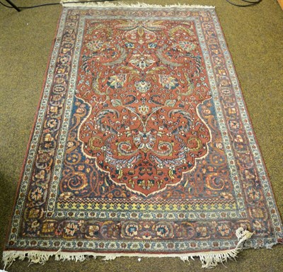 Lot 1273 - An Indian prayer rug, the brick red field of scrolling vines beneath the Mihrab framed by...