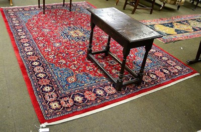 Lot 1286 - A Kashan style carpet, the blood red field of scrolling vines around an indigo flowerhead...