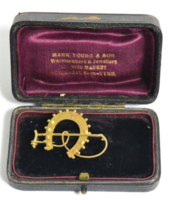 Lot 21 - A 9 carat gold horseshoe and crop brooch, cased