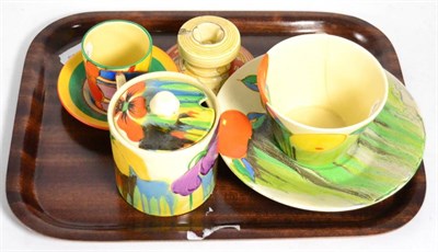 Lot 82 - Two Clarice Cliff cups and saucers, a Clarice Cliff candlestick and a preserve jar and cover