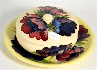 Lot 106 - A Walter Moorcroft 'Anemone' bowl and cover on a cream ground together with a similar plate (2)