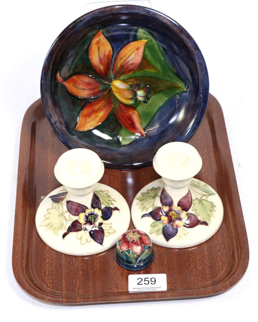 Lot 259 - A Moorcroft flambe dish, a pair of Moorcroft columbine candlesticks and a Moorcroft cover