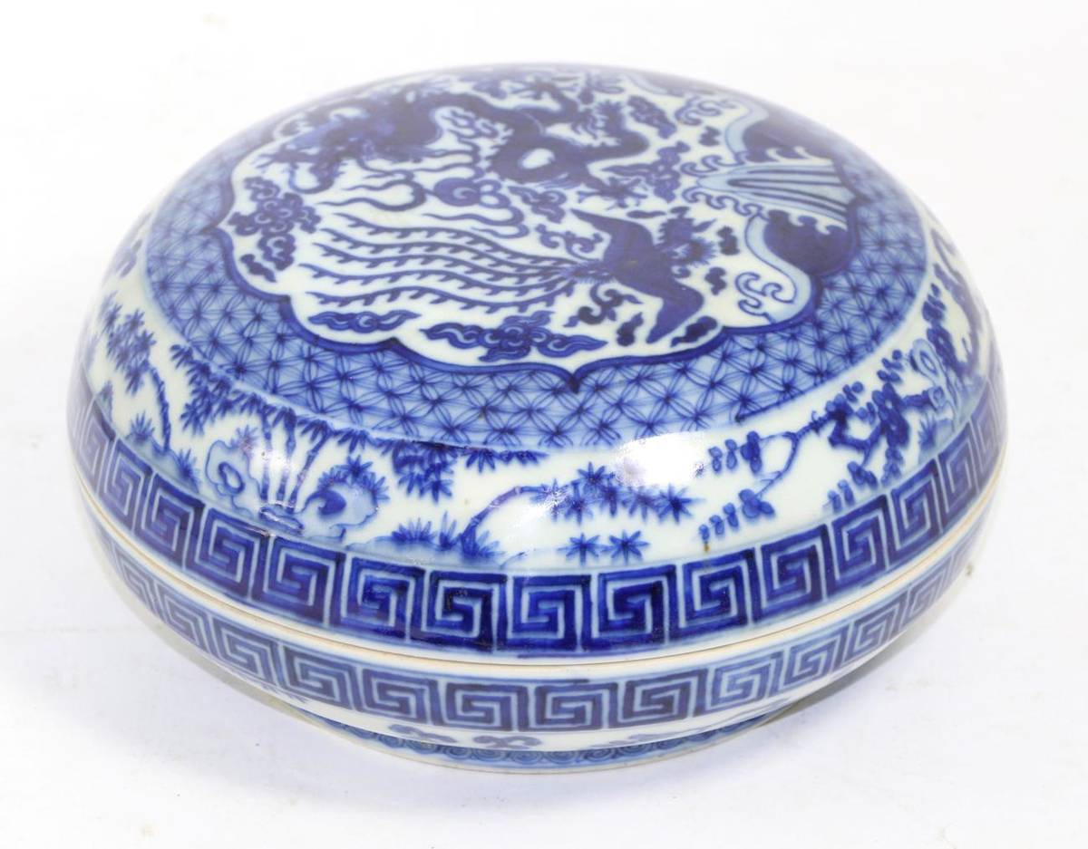 Lot 265 - A Chinese porcelain blue and white circular box and cover, with dragon and phoenix decoration,...